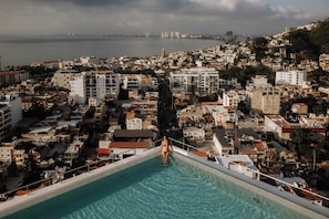 A pool with a view of a coastal cityscape.