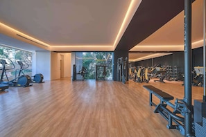 A spacious gym with cardio machines, weightlifting equipment, and a bench. - NEW Luxury Modern Condo in SOHO PV! Best Rooftop! (Puerto Vallarta)