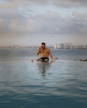 Ein Mann im Schwimmbecken, im Hintergrund eine Stadtlandschaft.