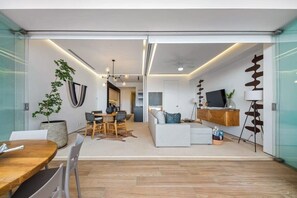 Un interior moderno con comedor, sofá y televisor.