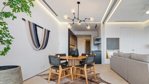 Un intérieur moderne avec un coin repas comprenant une table ronde en bois et des chaises, un luminaire suspendu et un tapis en peau de vache.