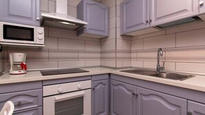 A kitchen with a microwave, coffee maker, oven, sink, and cabinets. - San Marino 28 - Studio (Los Cristianos)