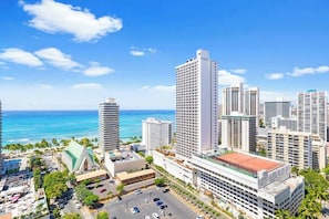 Um hotel moderno com vários andares, estacionamento e vista para o oceano.