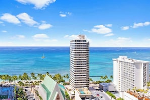 Um hotel alto com piscina e vista para o oceano.