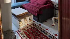 A compact room with a bed, a small table, a radiator, a lamp, and a refrigerator. - Un Appartementspacieux Calme Limite Vincennes (Fontenay-sous-Bois)