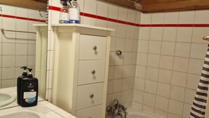 A bathroom with a wooden ceiling, white tiled walls, a bathtub, a shower, a sink, and a mirror. - Un Appartementspacieux Calme Limite Vincennes (Fontenay-sous-Bois)