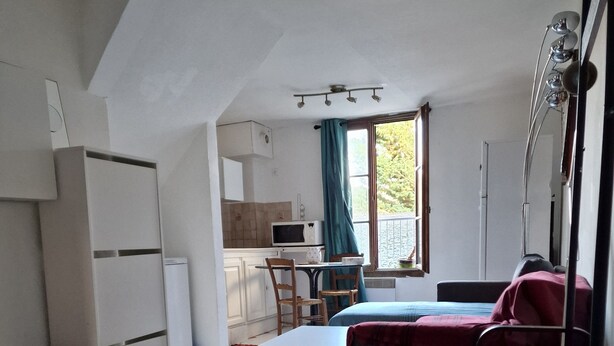 A compact living space with a kitchenette, a dining area, and a seating area with a sofa and a metal chair. - Un Appartementspacieux Calme Limite Vincennes (Fontenay-sous-Bois)