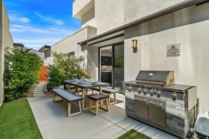 A patio with a barbecue grill, outdoor table, and chairs. - Skyline Views at Miralon - Palm Springs Perfection: Relax, Play & Recharge in a Gated Community (Palm Springs)