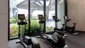 A gym with stationary bikes, treadmills, and a rowing machine. - Mega Style Apartments Melbourne Square (Southbank)