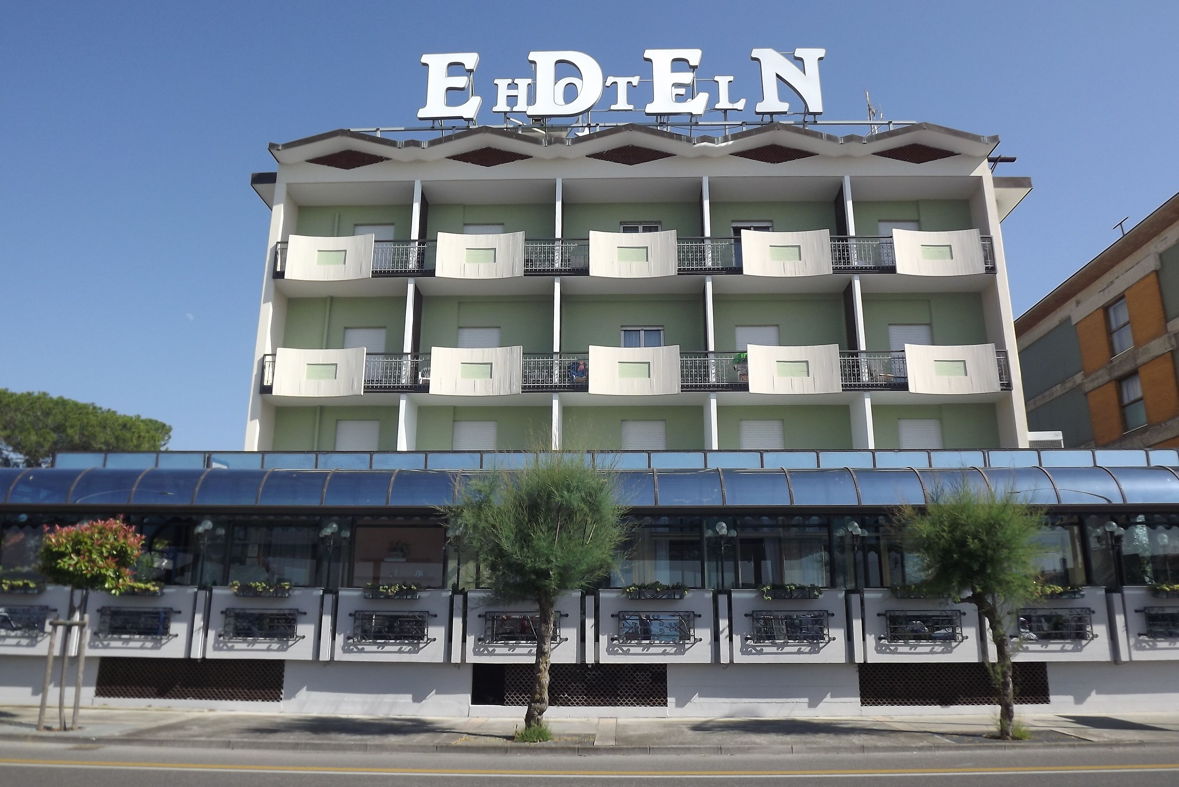 A multi-story hotel with balconies and a large sign reading "EHDTELN".