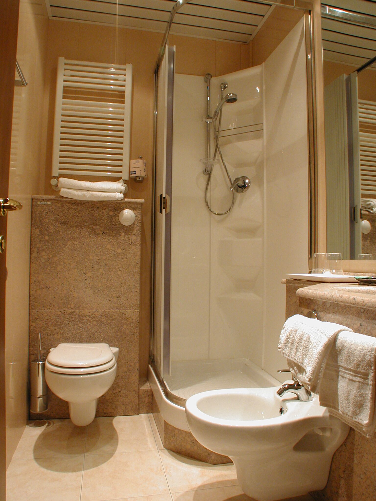 Een moderne badkamer met toilet, bidet en douche.