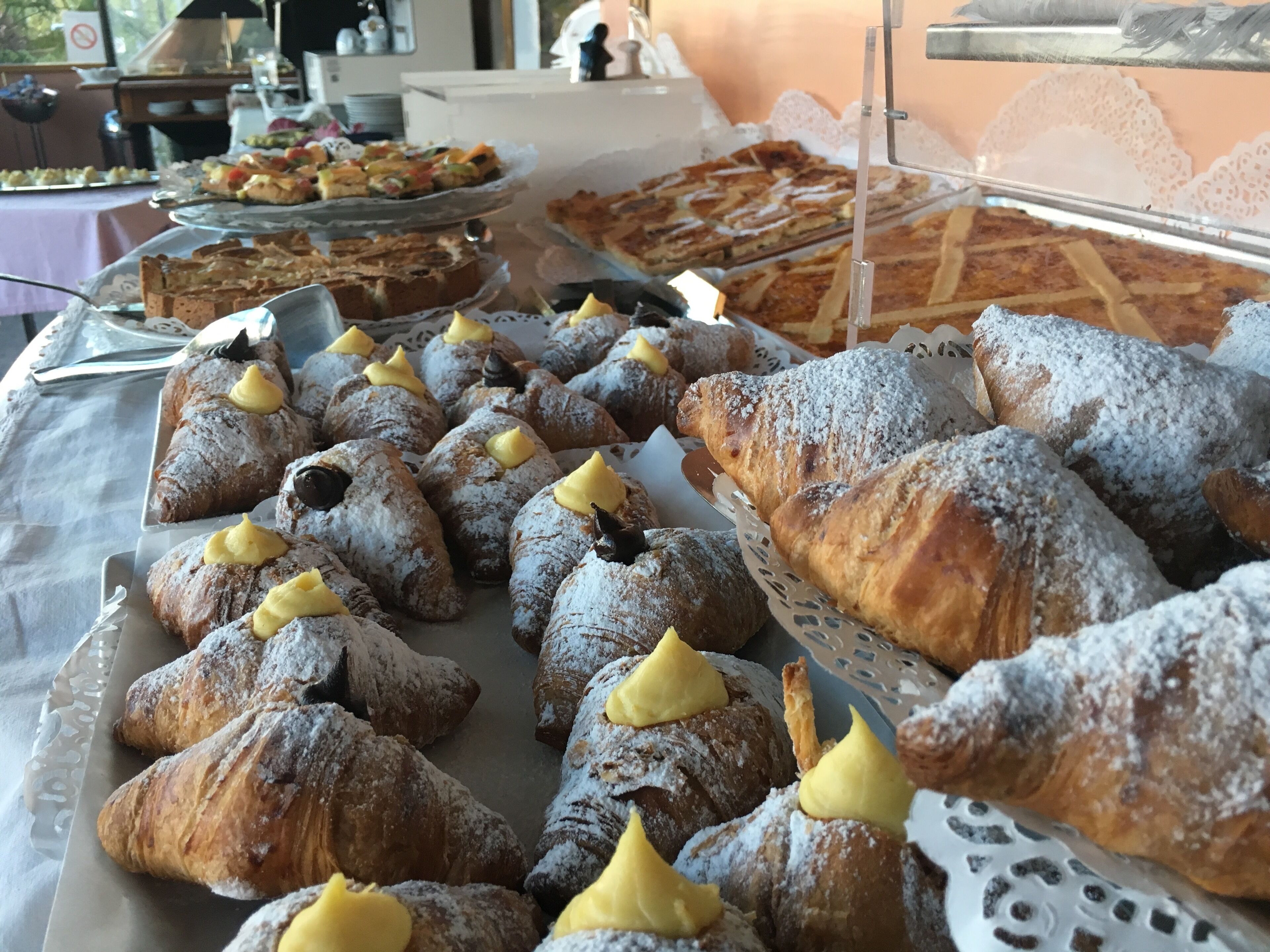 A buffet with various pastries including croissants and desserts.