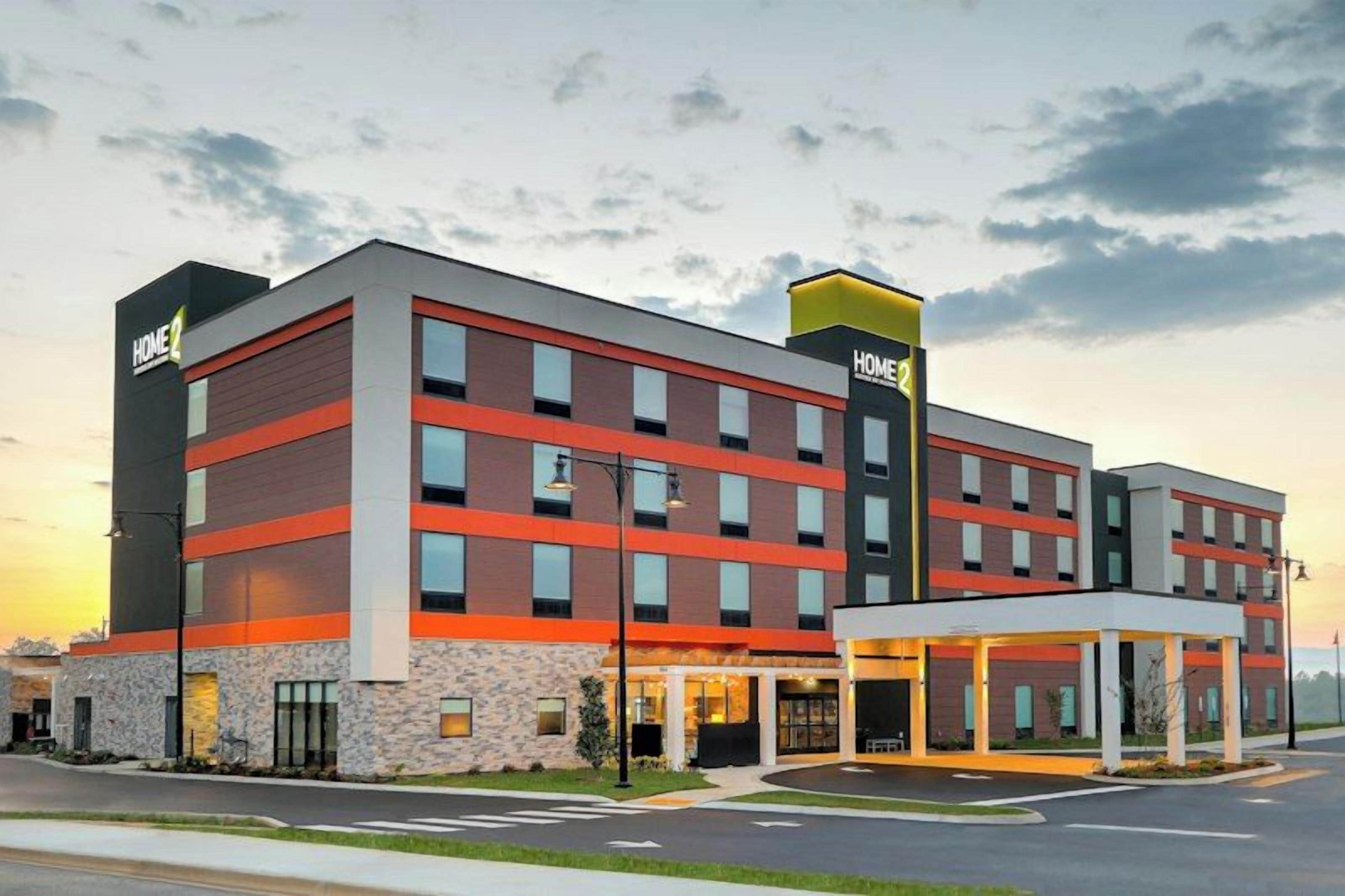 A multi-story hotel with a modern design, featuring a prominent entrance with a covered area and a visible sign.
