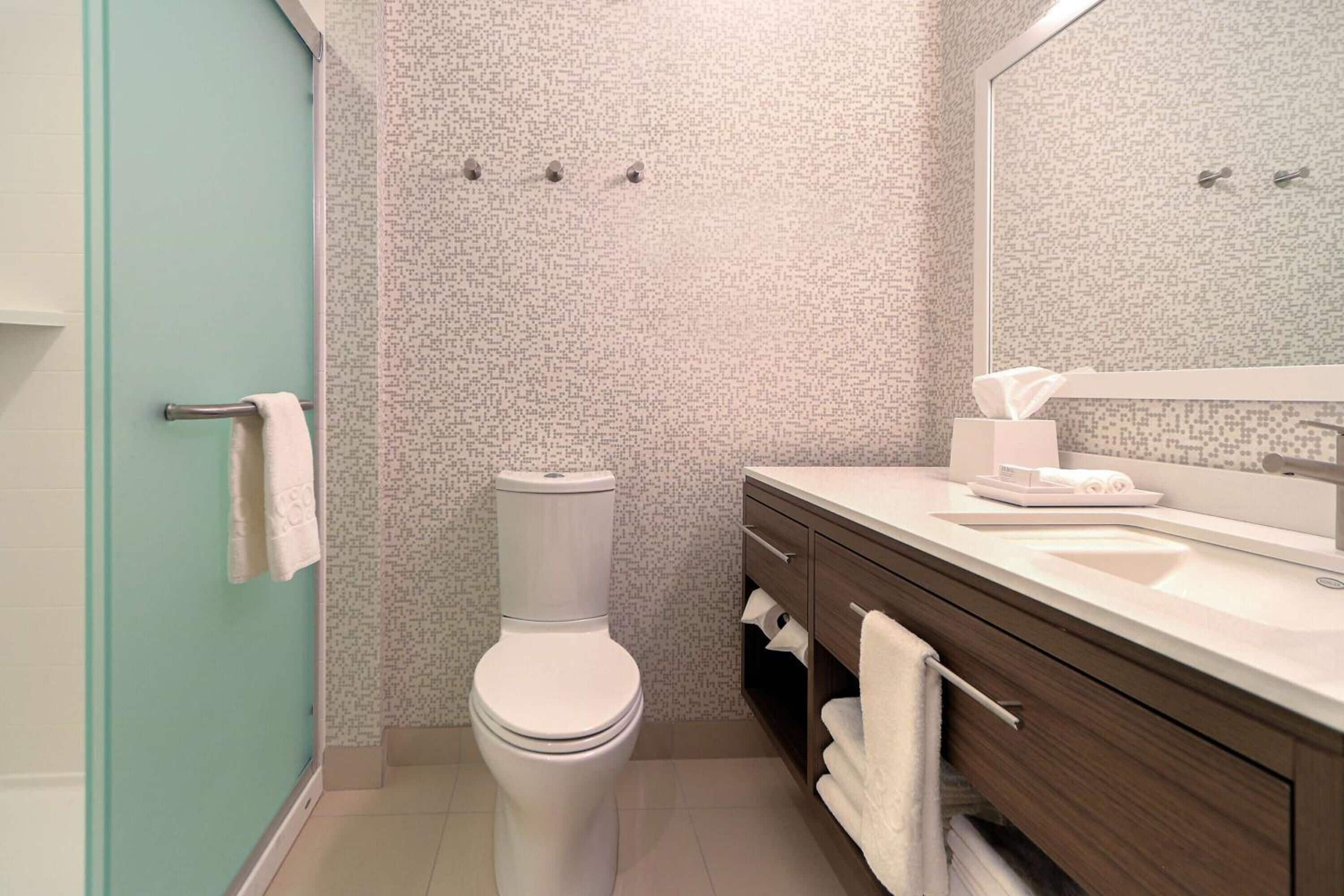 A modern bathroom with a toilet, a sink, and a shower area.
