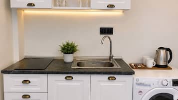 Suite | Privékeuken | Een koelkast, een waterkoker, kookgerei, borden en bestek