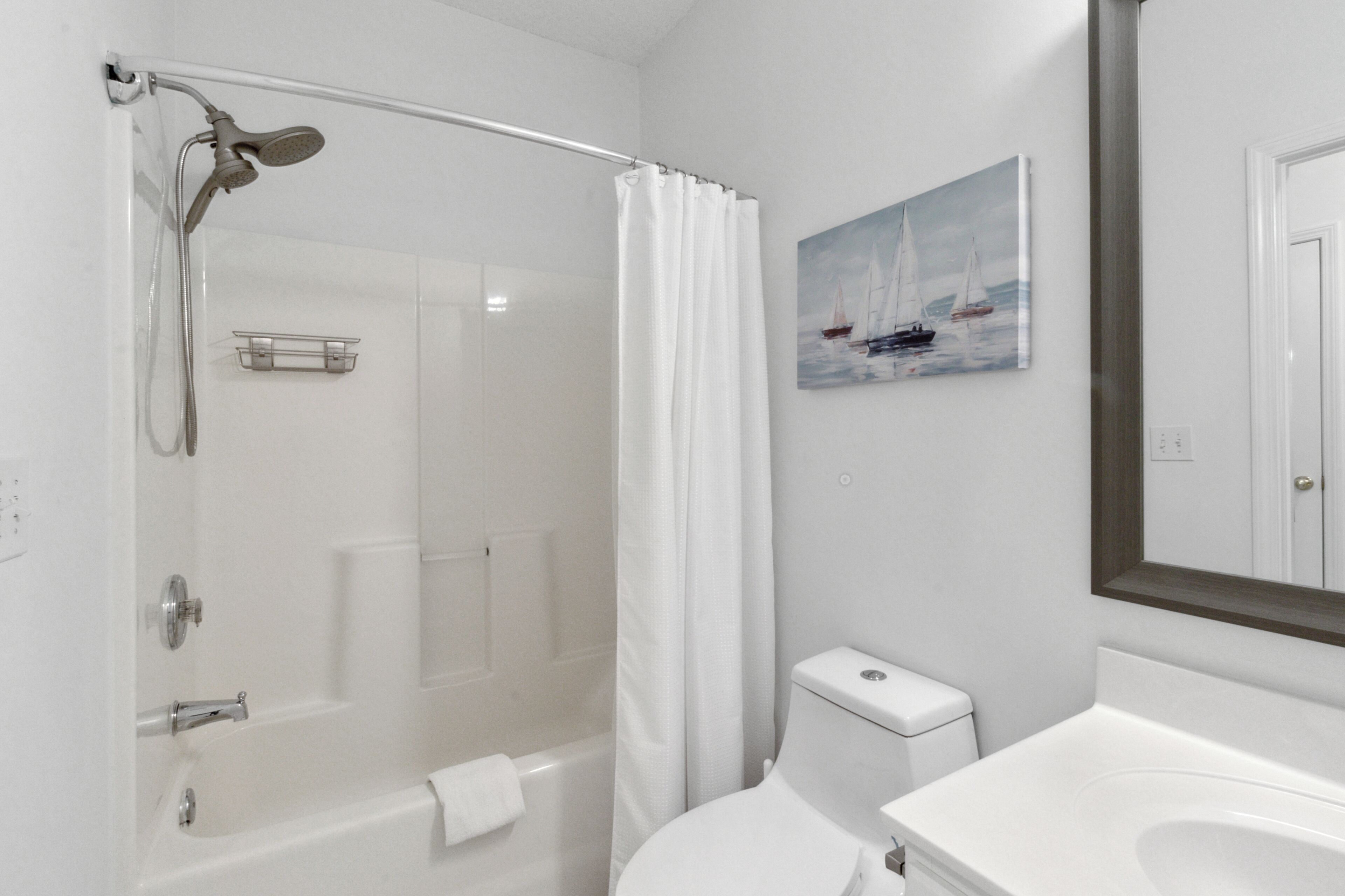A bathroom with a shower, toilet, and sink.