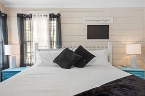 Cozy retreat with a neatly made bed, white headboard, and two bedside tables, each with a lamp and decorative item.