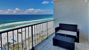 Un balcon avec vue sur l’océan et la plage.
