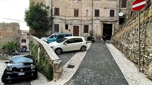 Una calle empedrada que lleva a un edificio con una señal de prohibido el paso.