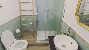Un baño con inodoro, lavamanos, ducha y una escalera.
