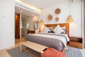 A modern bedroom with a large bed, bedside tables, a bench, and decorative wall art. - Romantic Zone Gem @ Nomada | Walk to Beach (Puerto Vallarta)