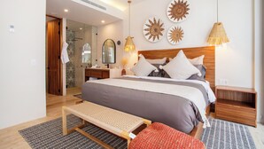 Een moderne slaapkamer met een groot bed, nachtkastjes, een bankje en decoratieve wandkunst.