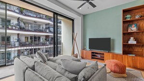 Een moderne woonkamer met een bank, een televisie en een boekenkast.