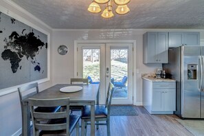 Enjoy meals in the kitchen with a coffee machine and dining area featuring a large window overlooking the backyard.