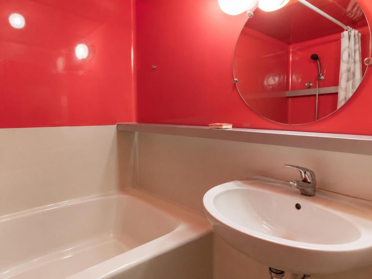 A bathroom with a bathtub, a sink, and a mirror.