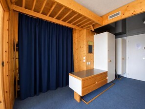 A room with a wooden ceiling, a blue curtain, a white wardrobe, and a wooden desk. - 5th floor, balcony, tv, 40m², Les Arcs (Les Arcs)