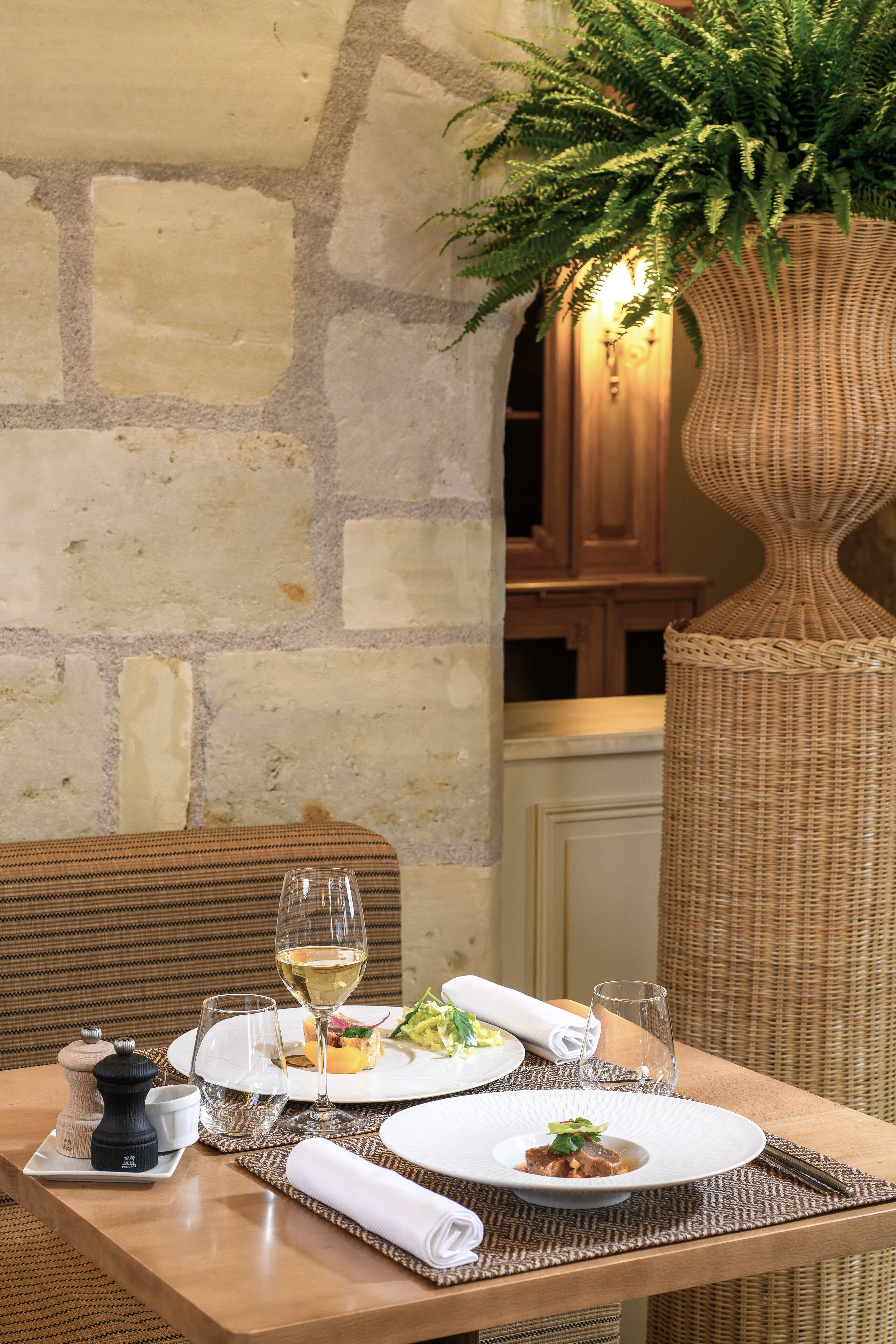 A dining table set with plates, glasses, and a centerpiece.