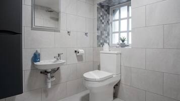 A modern bathroom with a toilet, sink, and a window with a view.