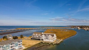 A coastal property with a large house, a pier, and a bridge in the background. - No Problem (Formerly The Teague House) by Seaside Vacations & Sales (Chincoteague Island)