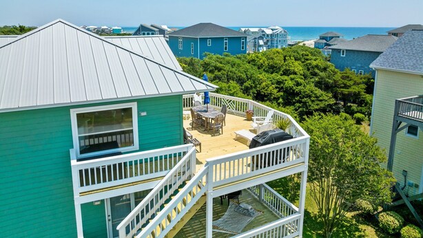 Une propriété résidentielle dotée d’un balcon donnant sur une plage, comprenant un coin repas et un hamac.