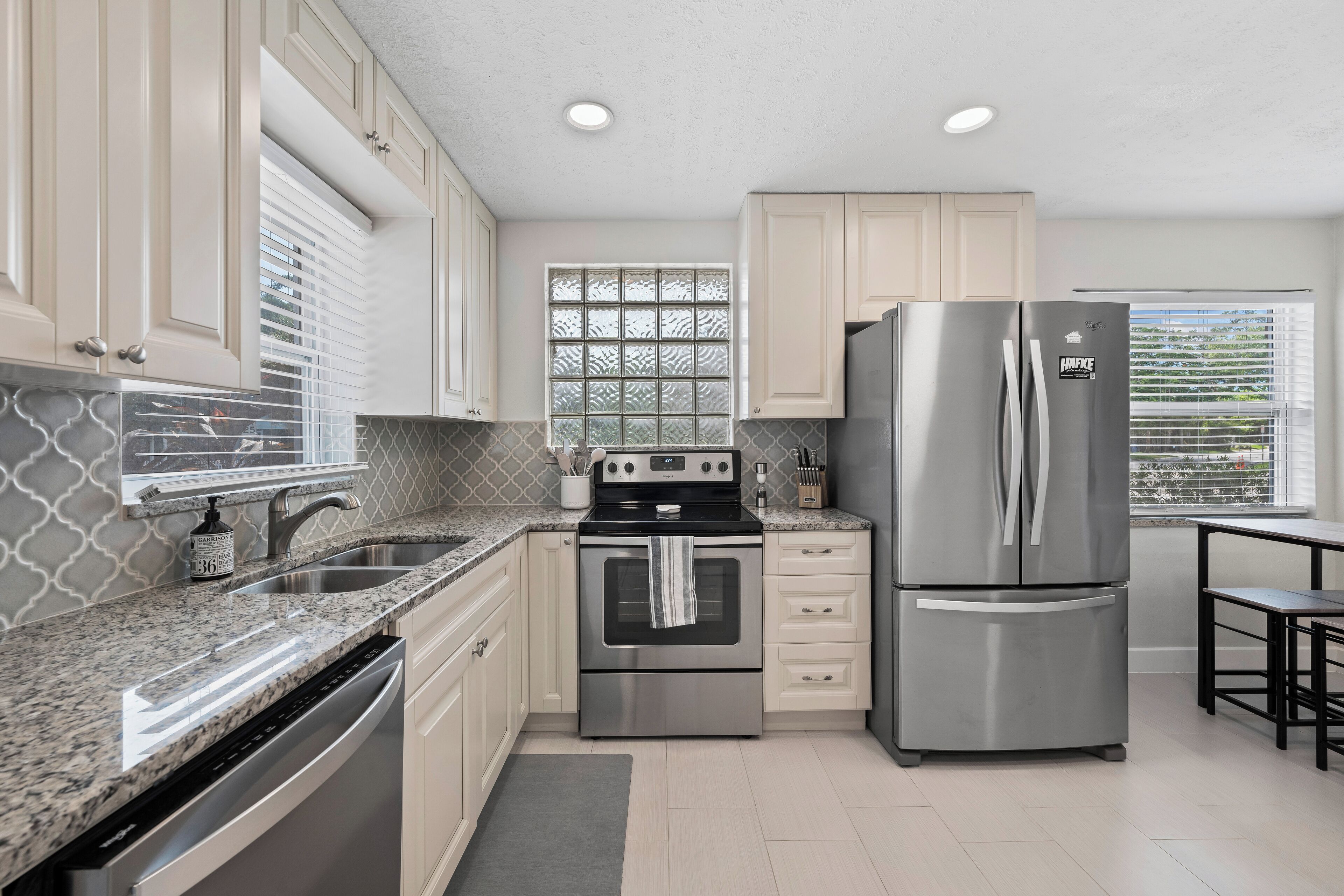 A kitchen with a stainless steel refrigerator, a built-in oven, and a dishwasher.