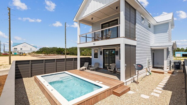 Une maison à deux étages dotée d’un balcon, d’une piscine et d’un patio couvert.