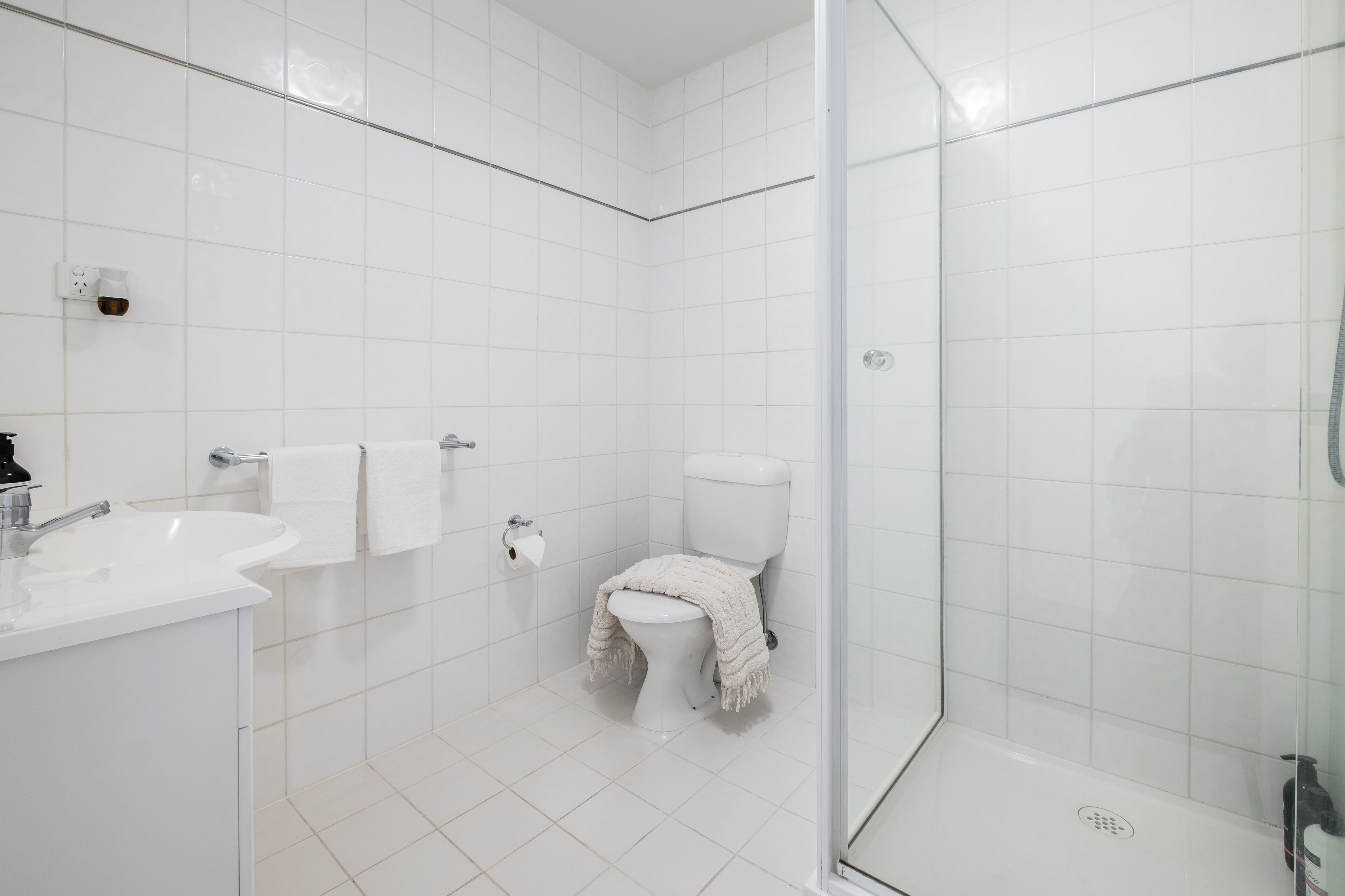 Ein modernes Badezimmer mit Waschbecken, Toilette und einer Duschkabine.