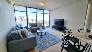 Deluxe Apartment | Living area | 55-inch LED TV with cable channels - Mega Style Apartments Capri (South Melbourne)