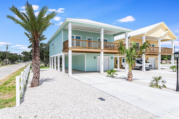 A two-story house with a balcony, a covered porch, and a driveway.