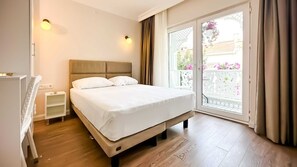 A hotel room with a bed, bedside tables, a wardrobe, and a balcony with a view. - hi Hotel Ivy Buyukada (Adalar)