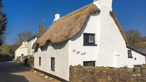 A white cottage with a thatched roof and a chimney, labeled "The White Cottage." - Coastal South Devon cottage near Thurlestone and Salcombe (Kingsbridge)