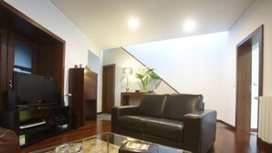 A living room with a leather sofa, a glass coffee table, a flat-screen TV, and a wooden entertainment unit. - 2stay - Luxury (Ponta Delgada)