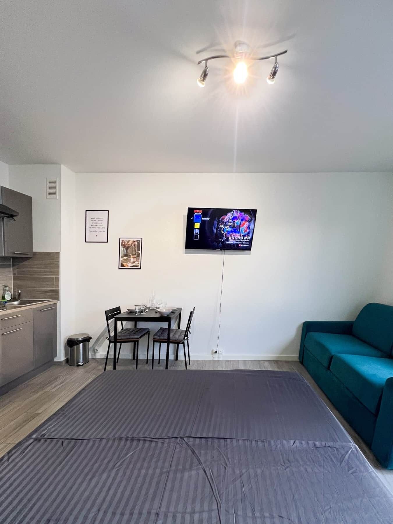 Studio avec un grand lit et un canapé confortable et une cuisine entièrement équipée (3)