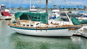 A boat docked at a marina with a clear view of the water and distant palm trees. - New Beach & Bay Retreat Full of Amenities! (Long Beach)