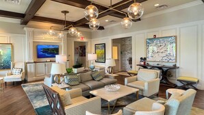 A spacious living room with a large sofa, multiple armchairs, a coffee table, and a television. - Always Summer on Sunshine Ridge (Kissimmee)