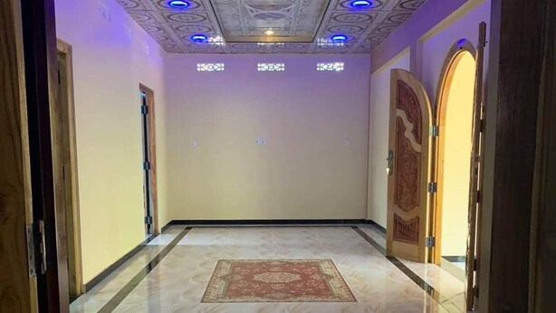 A hallway with a patterned ceiling, a marble floor, and a wooden door on the right. - A Stunning, Newly Built 3-bedroom Property to Rent (Iyakachchi)