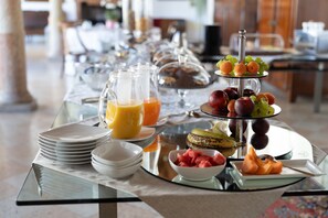 A breakfast buffet with various fruits, a fruit display, and a glass pitcher of orange juice. - Residenza Villa Vecelli (Mozzecane)
