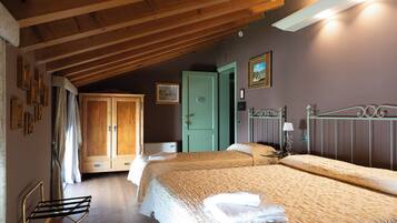 A bedroom with two beds, a wooden ceiling, a green door, and a metal headboard.