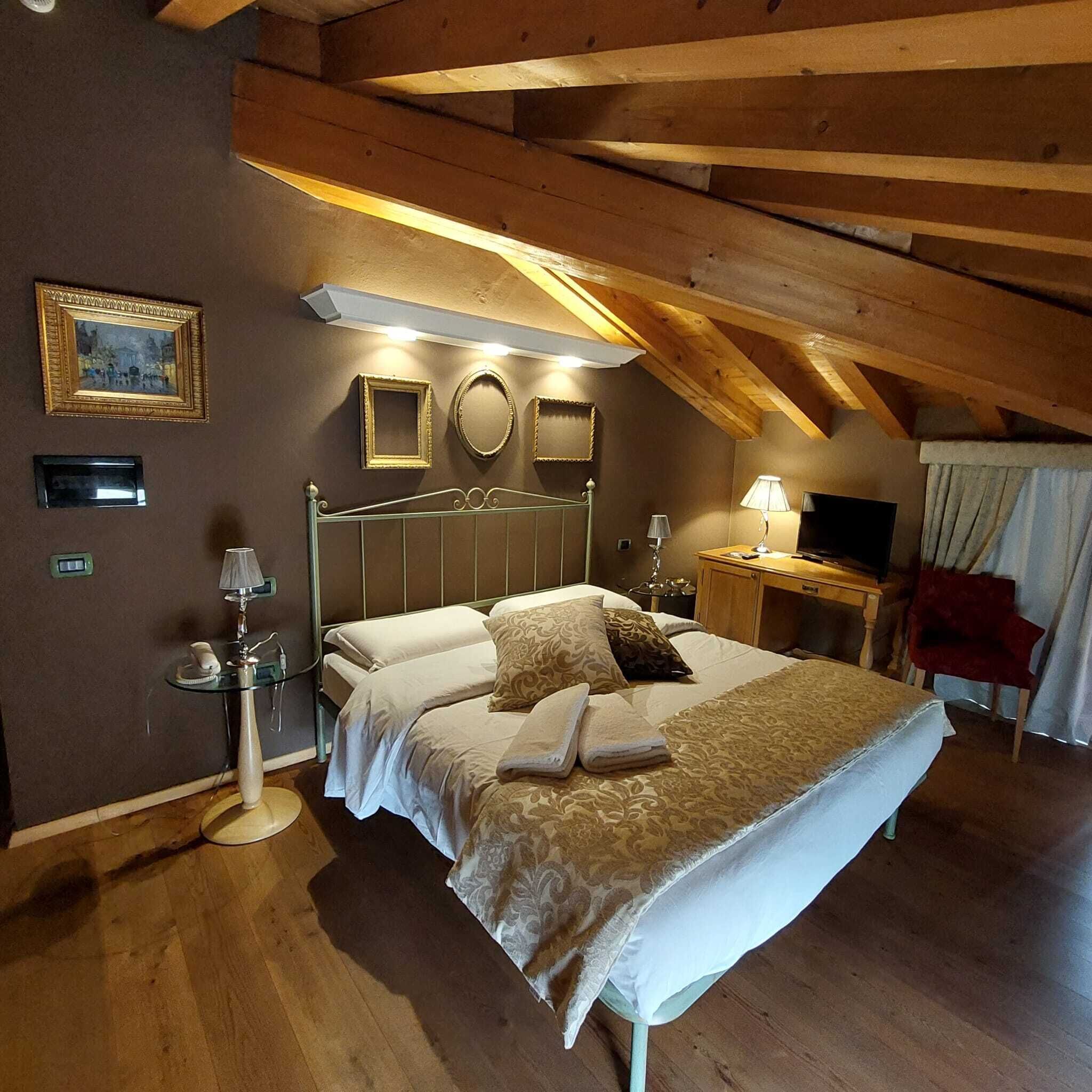 Ein Schlafzimmer mit einem großen Bett, Nachttischen, einem Spiegel und einem Fernseher.