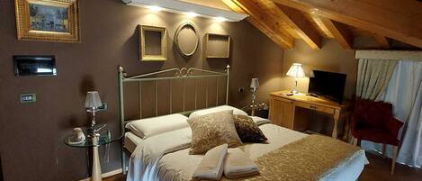 Un dormitorio con una cama grande, mesitas de noche, un espejo y un televisor.